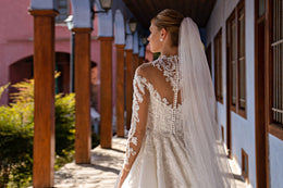 Sheer wedding veil cascading down the back with a delicate lace-trimmed edge and scattered sparkle