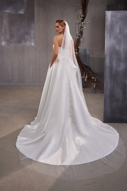 Long white wedding veil with a wide train, fine dotted tulle, and ornate embellished edging