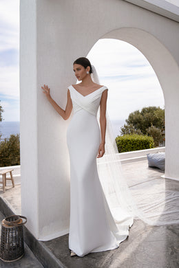 Long white tulle wedding veil with scattered pearl accents, flowing behind the gown
