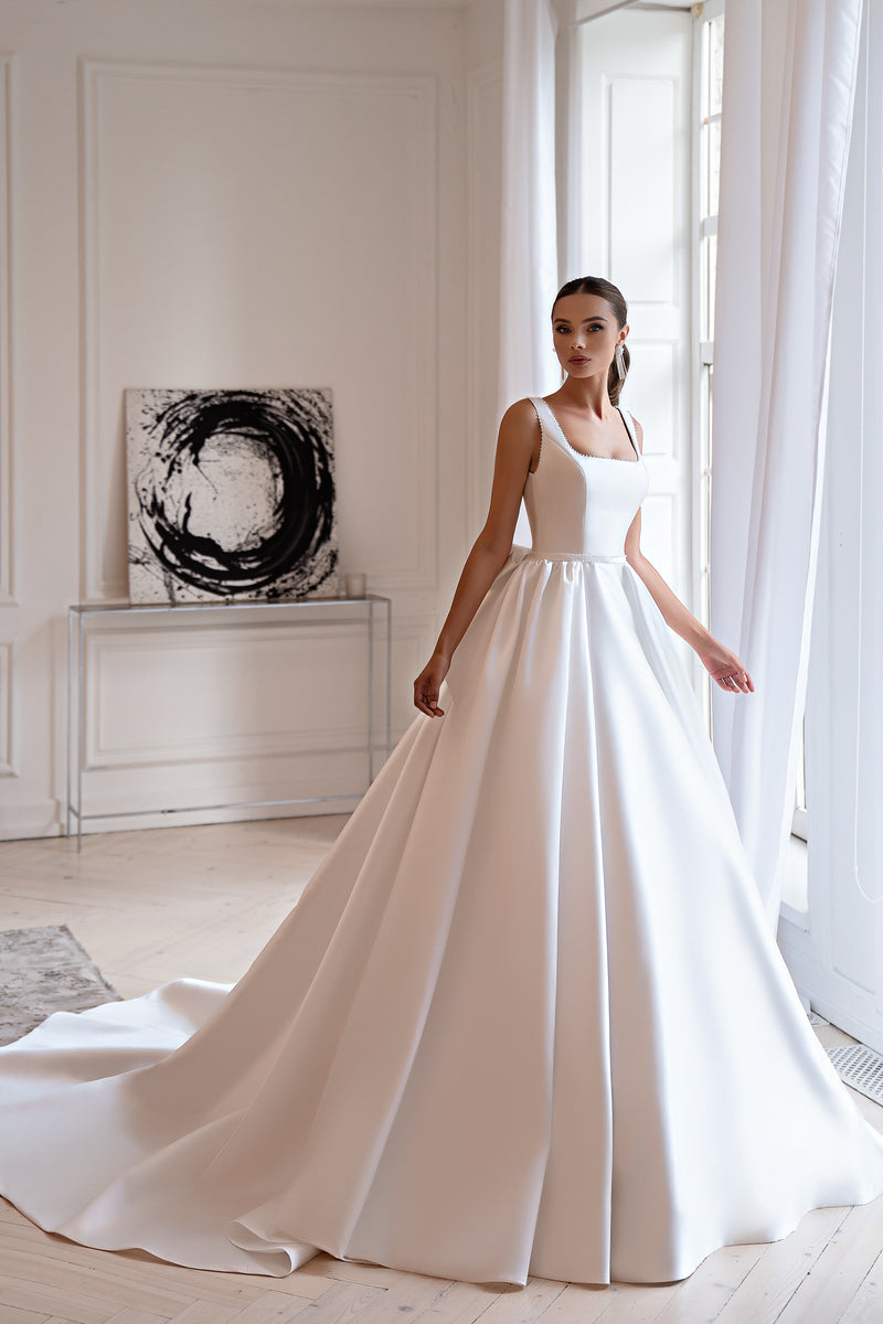 Ivory ball gown wedding dress with a square neckline, sleeveless bodice, and sweeping train