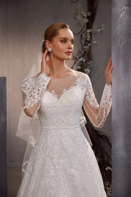 Close-up of a sheer wedding veil draped behind the shoulder, with a visible scalloped lace edge