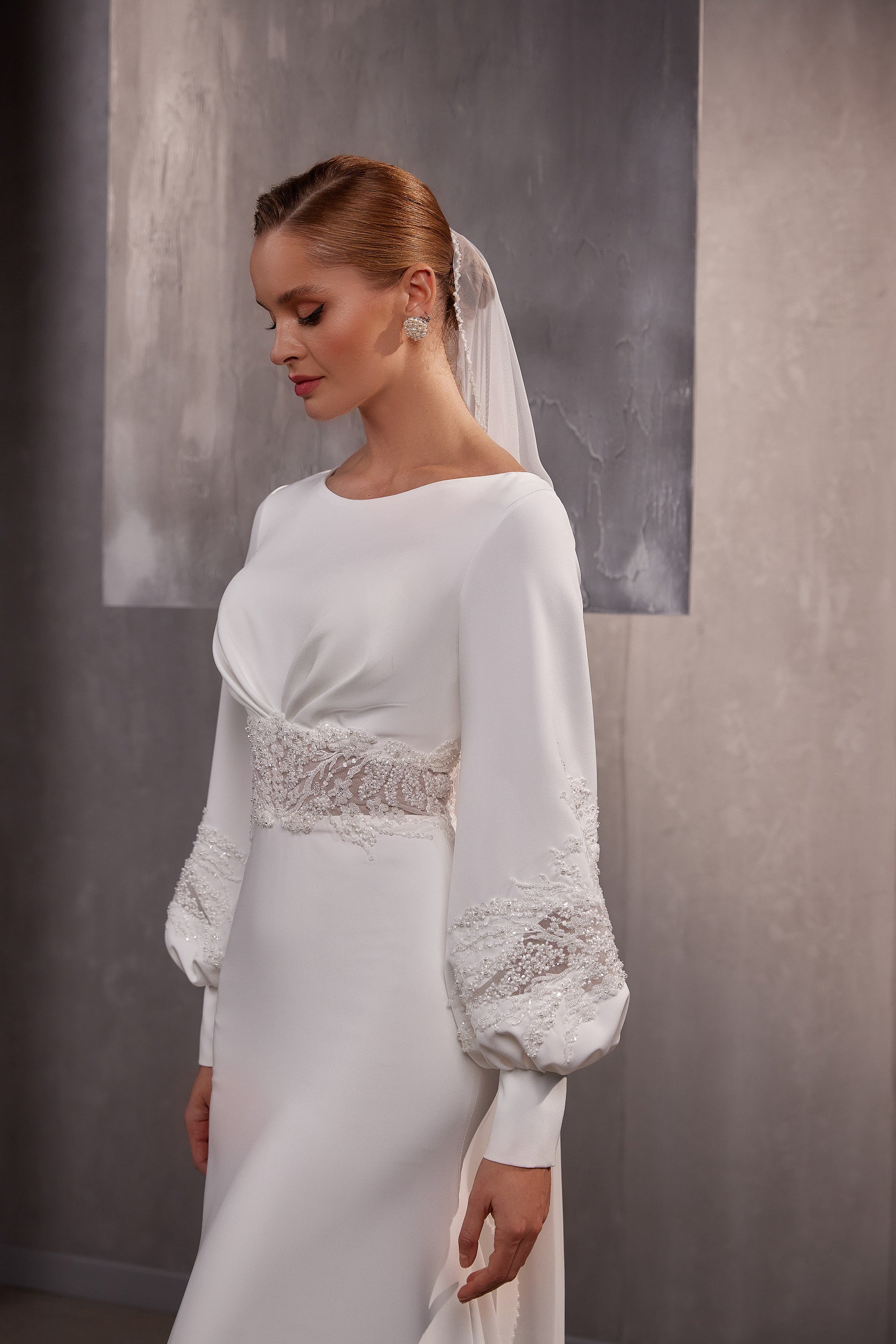 Close view of a sheer white wedding veil draped from the crown and falling behind the shoulders