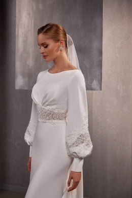 Close view of a sheer white wedding veil draped from the crown and falling behind the shoulders