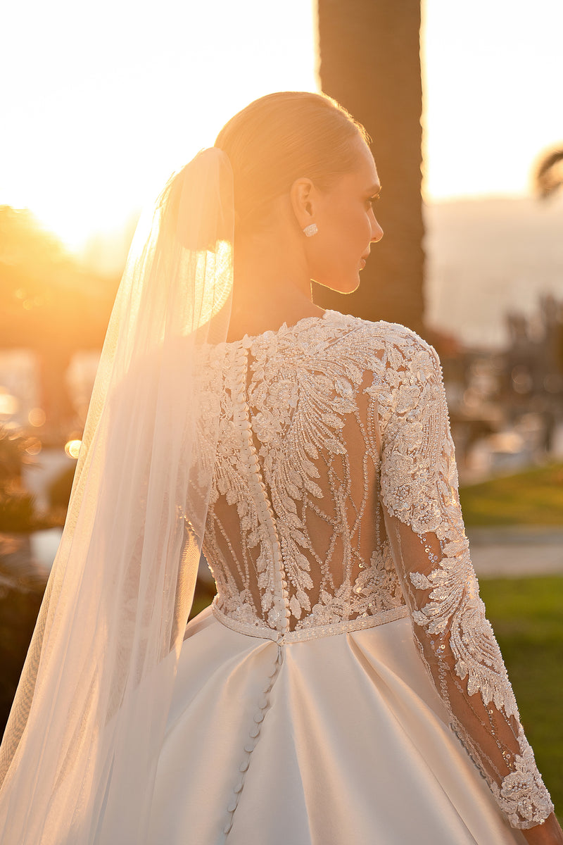 Embellished sheer lace back and long sleeves on an ivory ball gown wedding dress
