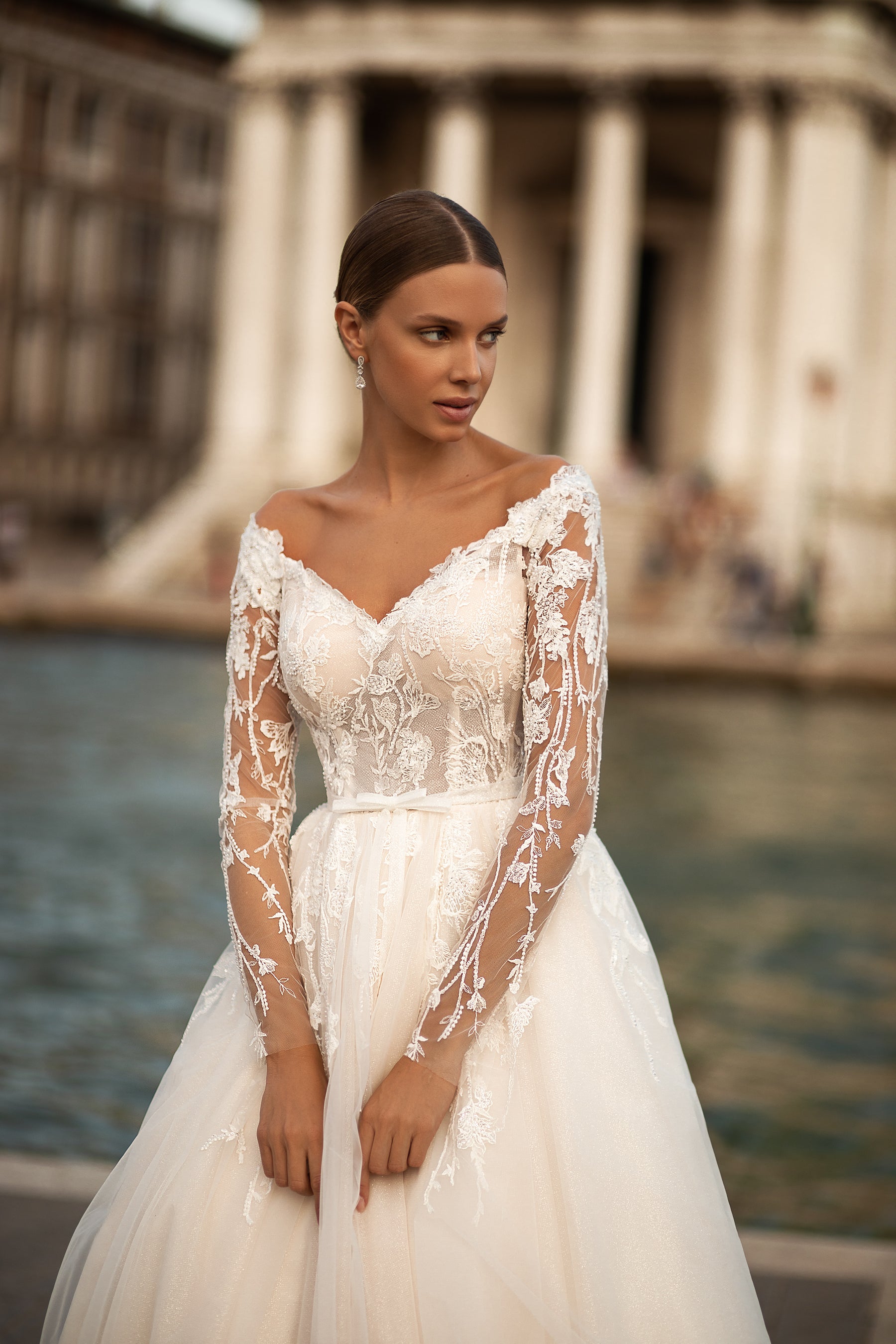 Elegant A-Line Wedding Gown with Tulle Skirt, Small Bow at Waist, Long Sleeves with Lace, Buttons Back, and Court Train
