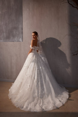 Long white wedding veil flowing into a wide trailing edge with scattered floral appliqués and shimmer