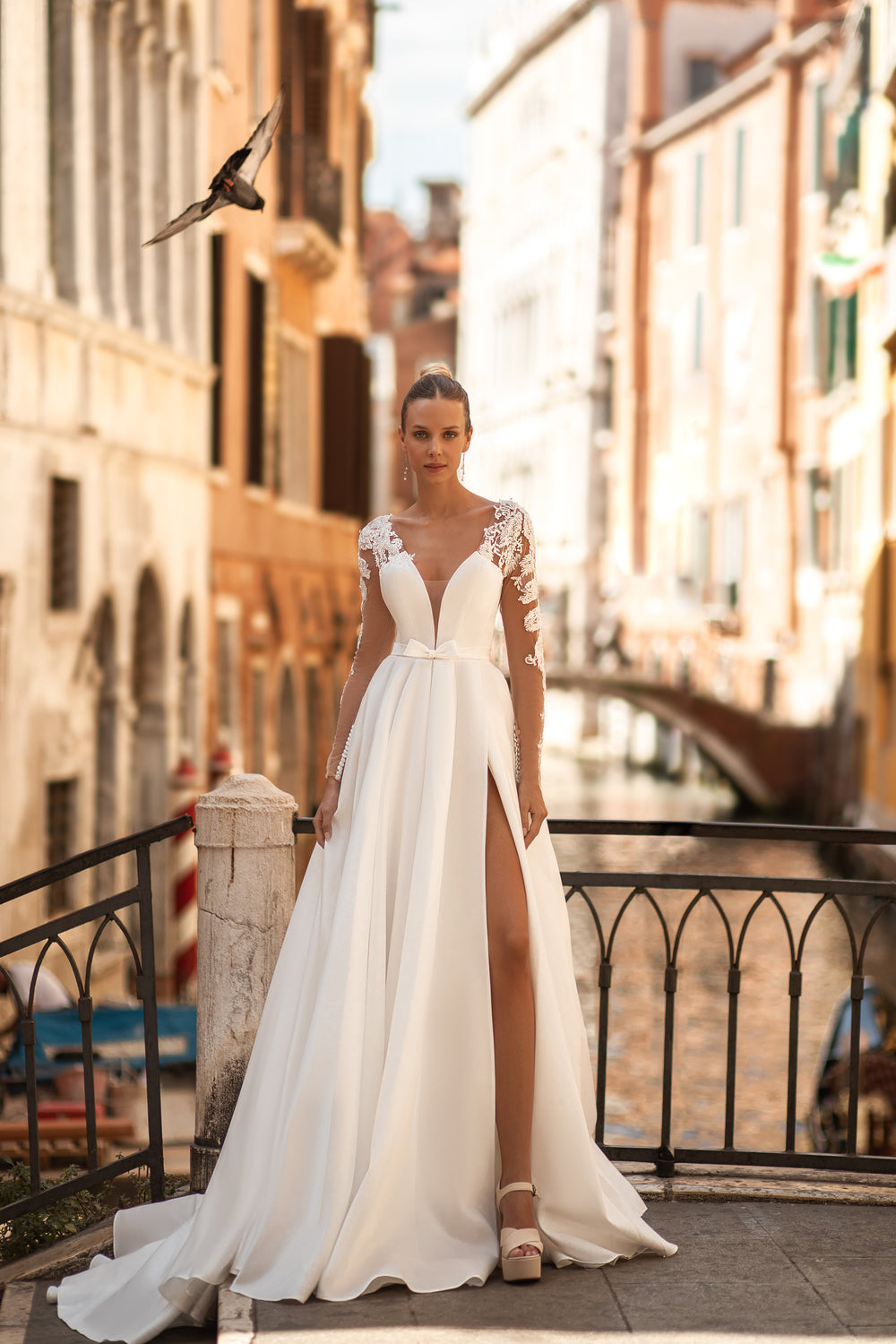 Elegant A-Line Wedding Gown with Deep V-Neck, Low Back, Long Lace Sleeves, Bow at Waist, and Slit Skirt