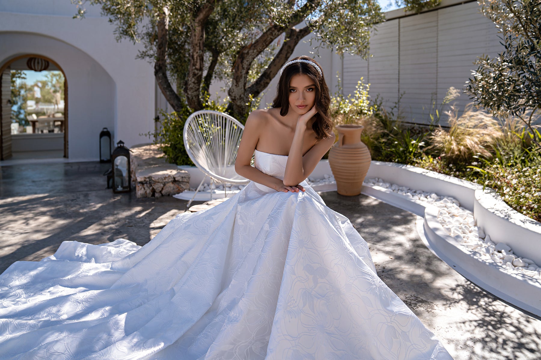 Full ivory ball gown wedding dress featuring a straight neckline, floral texture, and extended train