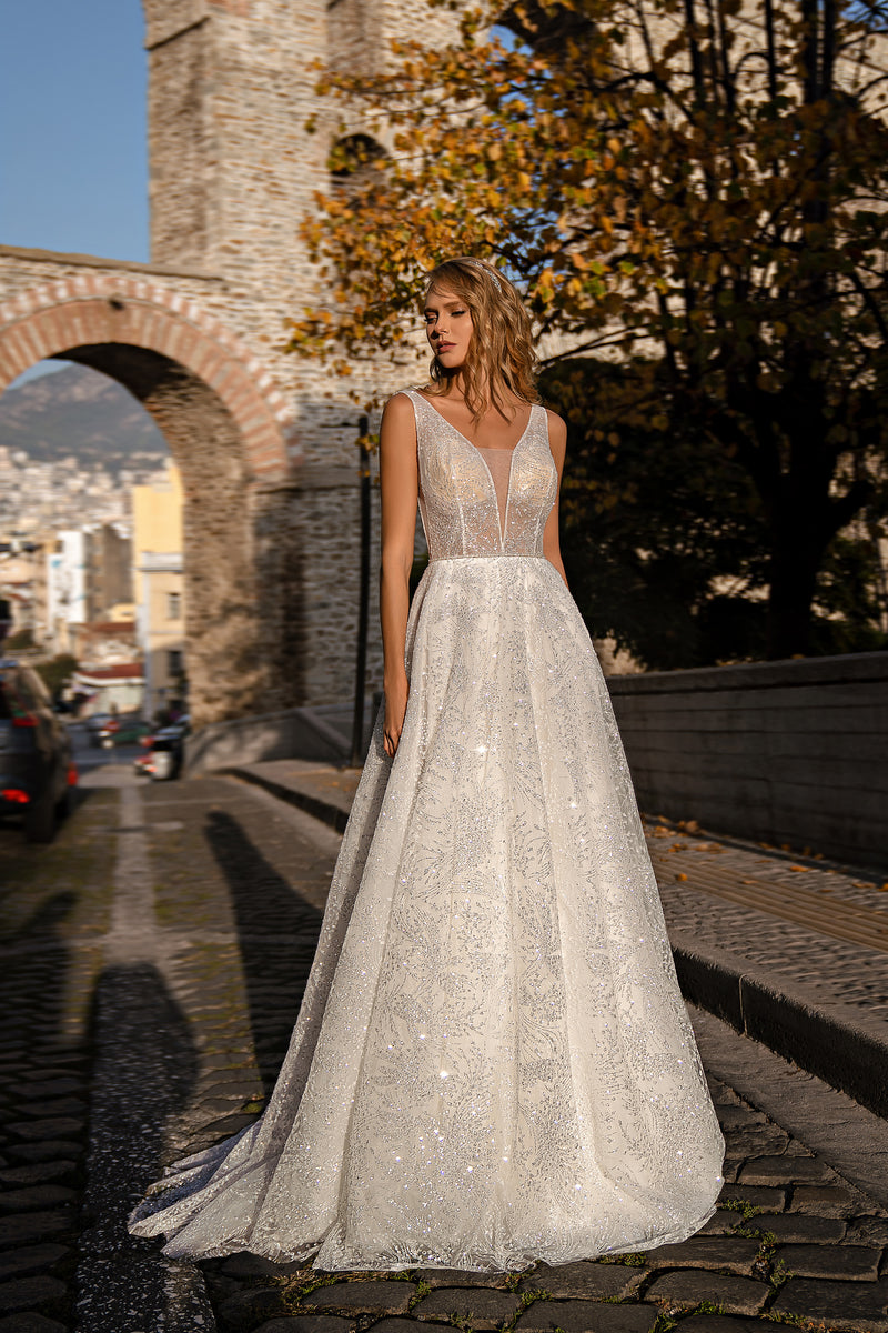 Ivory glitter wedding dress with a plunging V-neckline, sleeveless bodice, A-line skirt, and train
