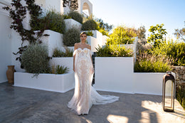 Full-length ivory wedding dress with floral lace, draped tulle sleeves, fitted silhouette, and trailing train