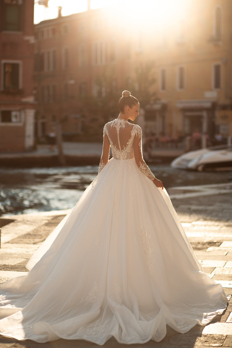 Lace illusion back and sweeping train on an ivory ball gown wedding dress