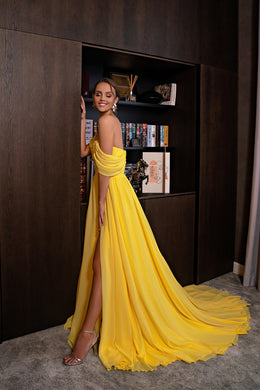 Yellow evening dress showing the draped back, thigh-high slit, and flowing floor-length train