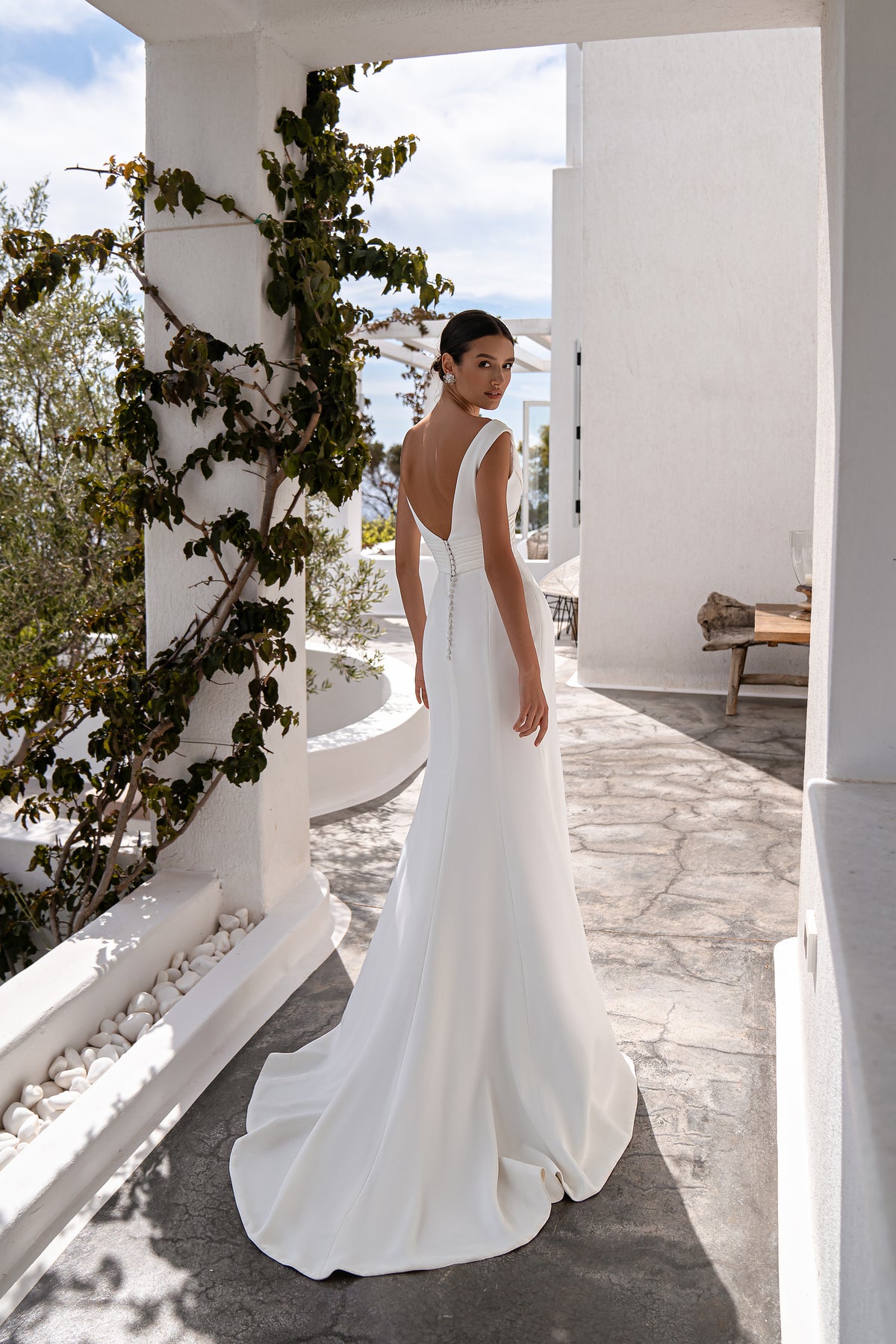 Ivory wedding dress with a low back, center buttons, and softly pooling train