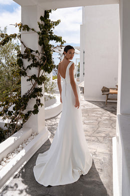 Ivory wedding dress with a low back, center buttons, and softly pooling train