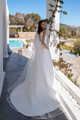 Romantic Minimalist Wedding Dress with Boat Neck, Tulle Inserts, Boho Lace, and Flared Skirt with Train and Pockets.