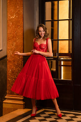 Full-length red evening dress with a fitted lace bodice and voluminous tiered midi skirt