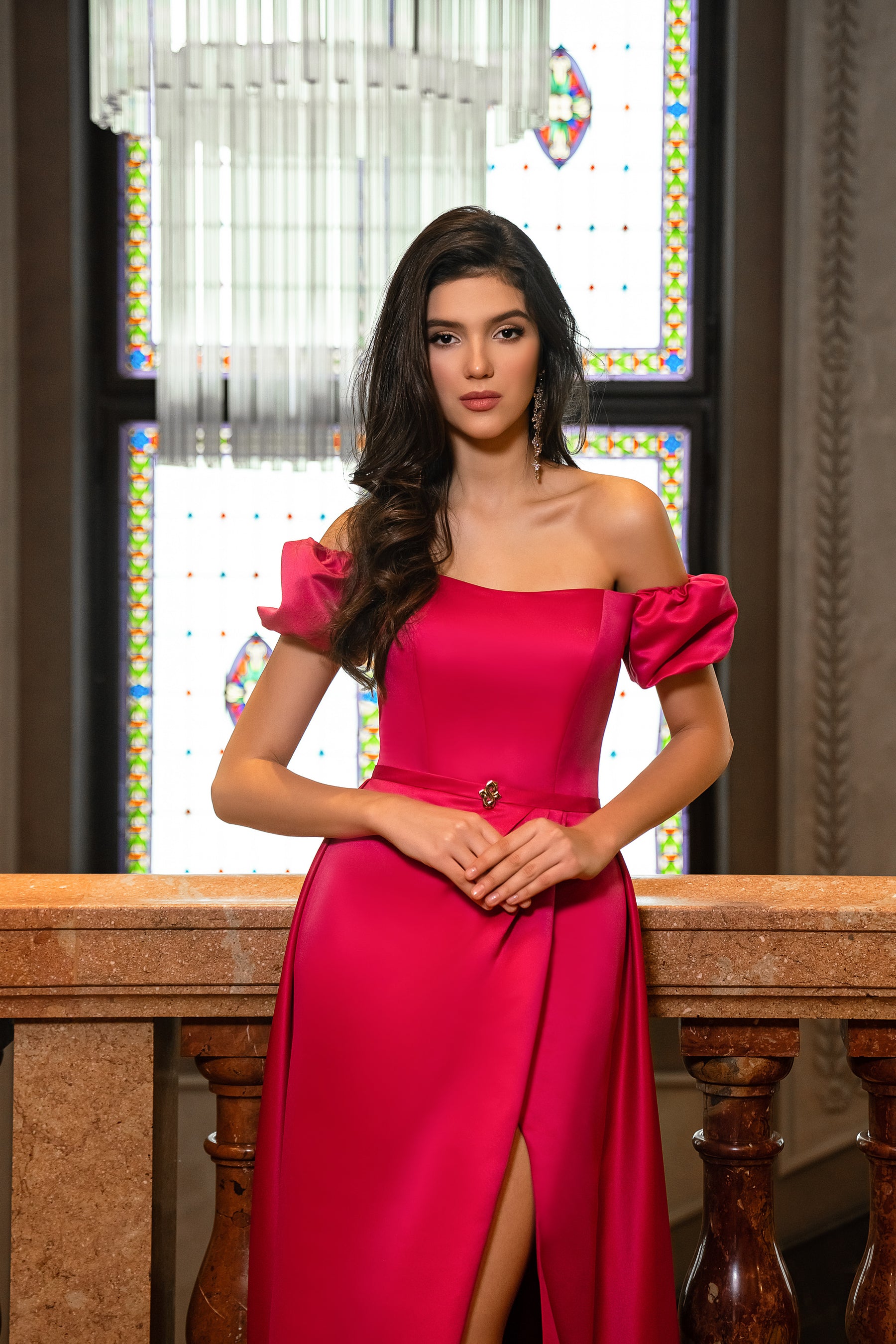 Fuchsia evening dress with an off-shoulder neckline, puff sleeves, fitted bodice, and front slit
