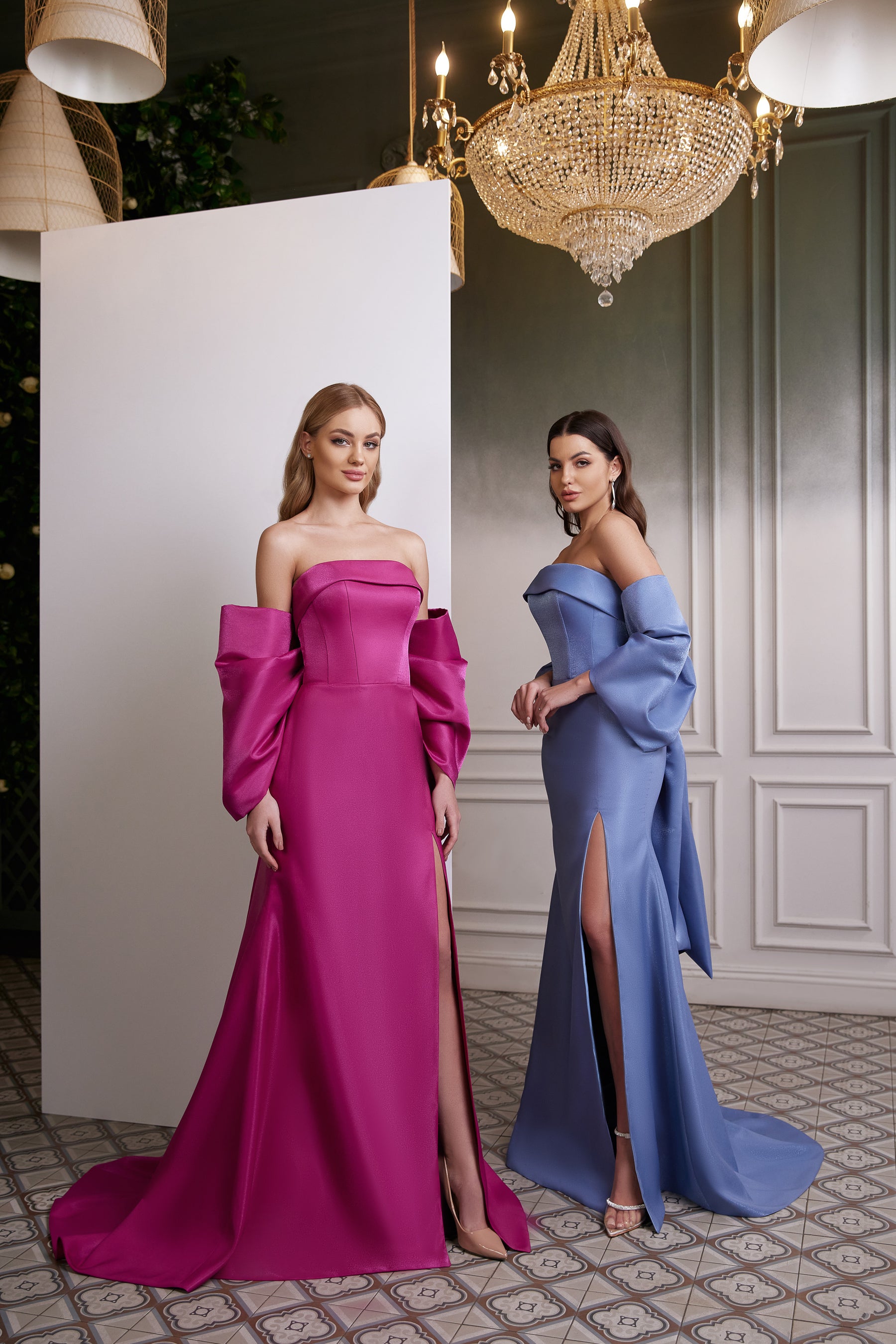Magenta and blue off-the-shoulder satin evening dresses with long sleeves, thigh-high slits, and trains