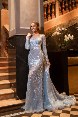 Silver-blue evening dress with long sleeves, boat neckline, floral embellishments, and a sweeping train