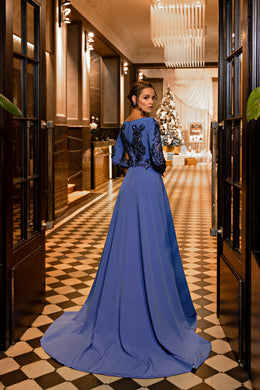 Sapphire evening dress showing an embellished back, long sleeves, and a sweeping floor-length train