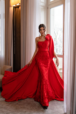 Red lace mermaid evening dress with a one-shoulder bow and flowing detachable cape-like train