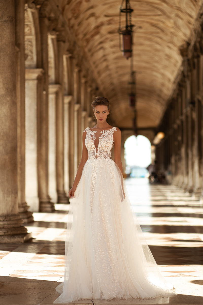 Ivory A-line wedding dress with a lace bodice, deep V-neckline, slim straps, and sparkling tulle skirt
