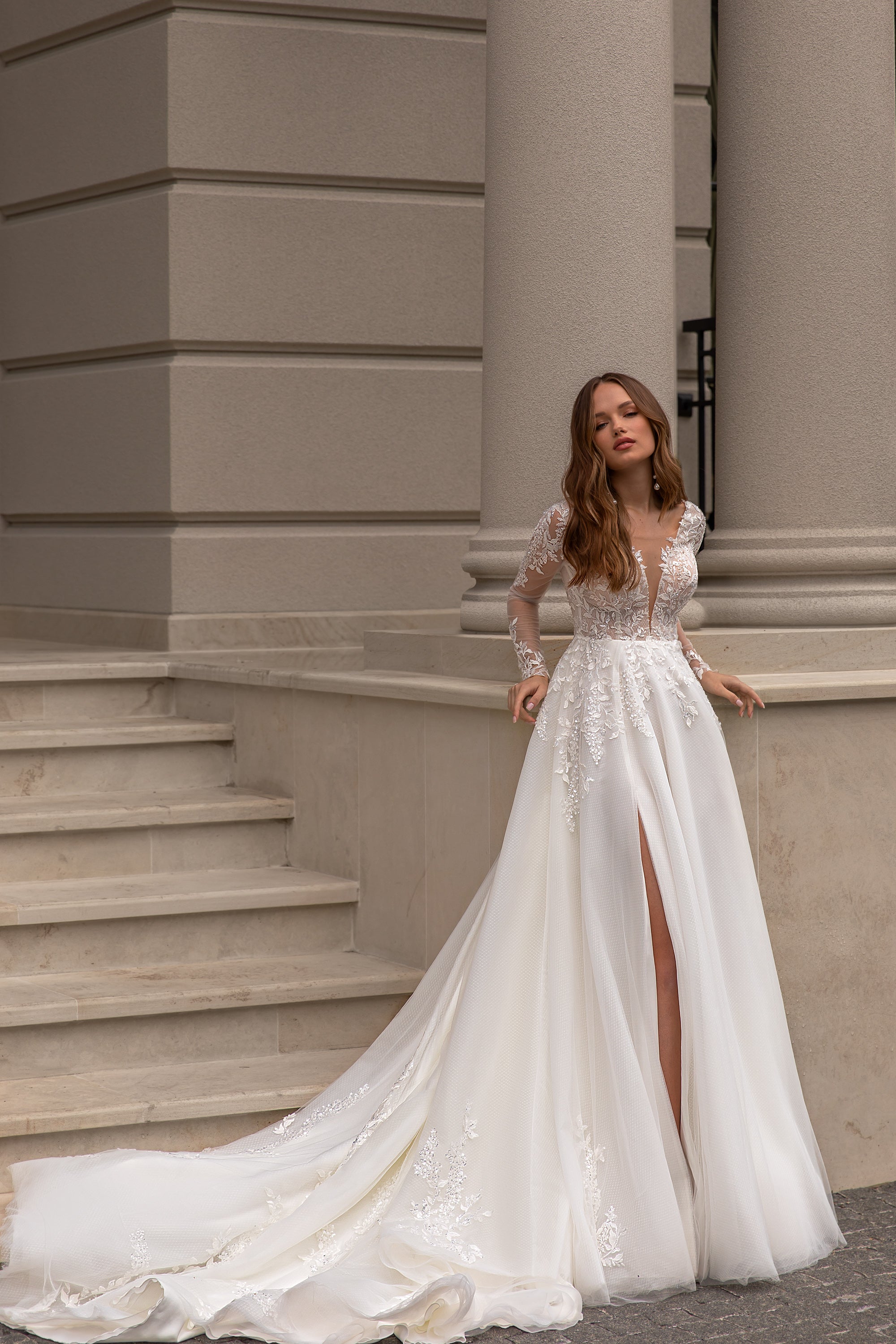 Ivory wedding dress with a plunging V-neck, floral lace appliqués, thigh-high slit, and sweeping train