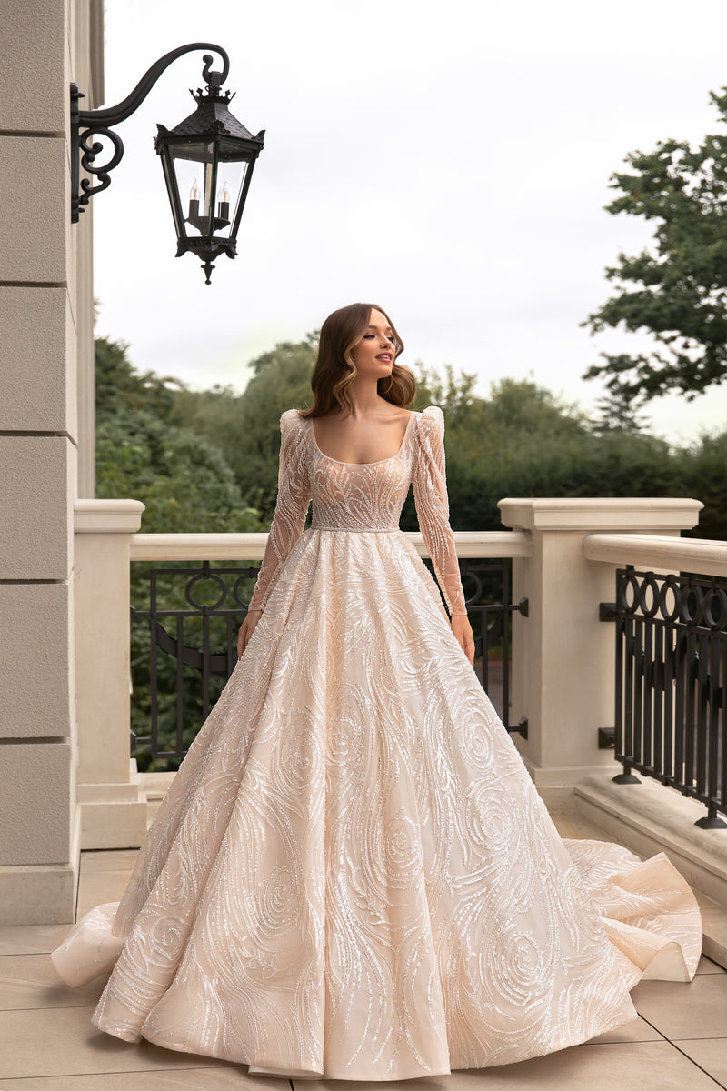 Ivory A-line wedding dress with a square neckline, sheer puff sleeves, and sequined swirl embellishment