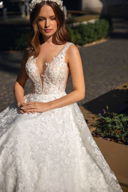 Close-up of floral lace appliqués and plunging V-neckline on an ivory wedding dress