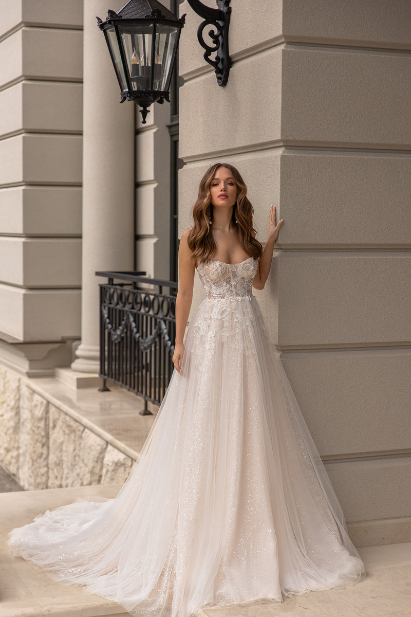 Ivory A-line wedding dress with sweetheart neckline, spaghetti straps, floral lace bodice, and sparkling tulle skirt