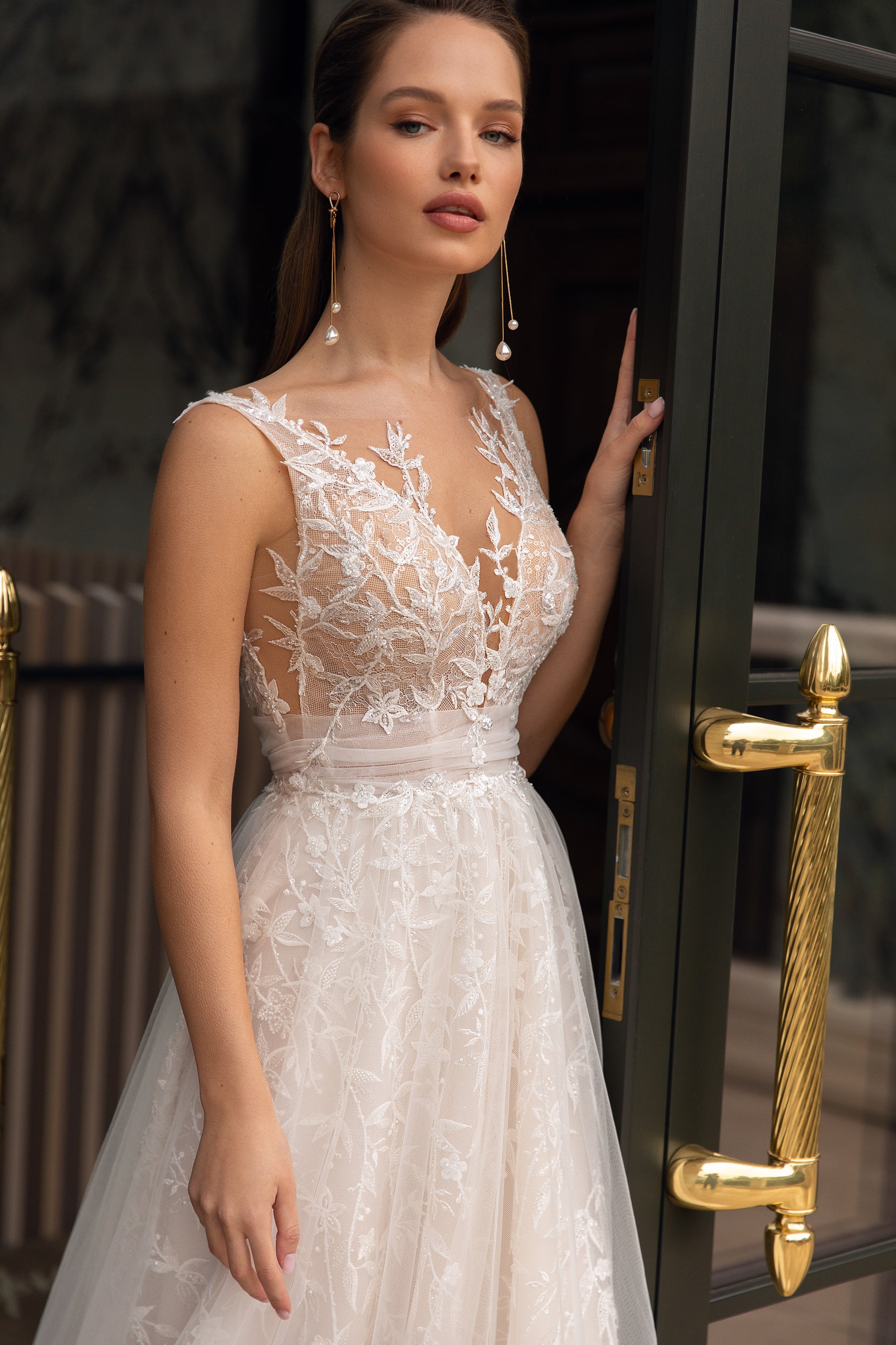 Close-up of an ivory wedding dress bodice with floral lace, a deep V-neckline, and slim straps