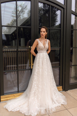 Ivory A-line wedding dress with a deep V-neck, floral lace bodice, tulle skirt, and sweeping train