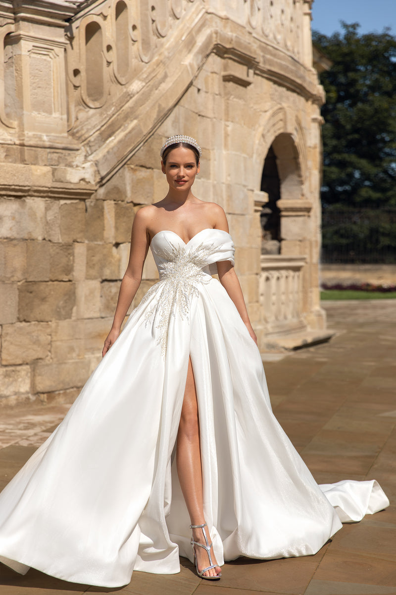 Ivory A-line wedding dress with sweetheart neckline, draped sleeves, beaded bodice, thigh-high slit, and train